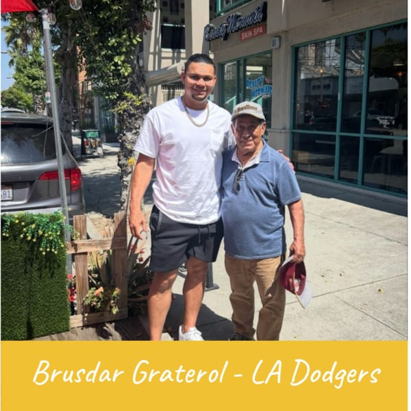 Brusdar Graterol from the LA Dodgers posing with an older man outside Venezuelan Chamo Cuisine.